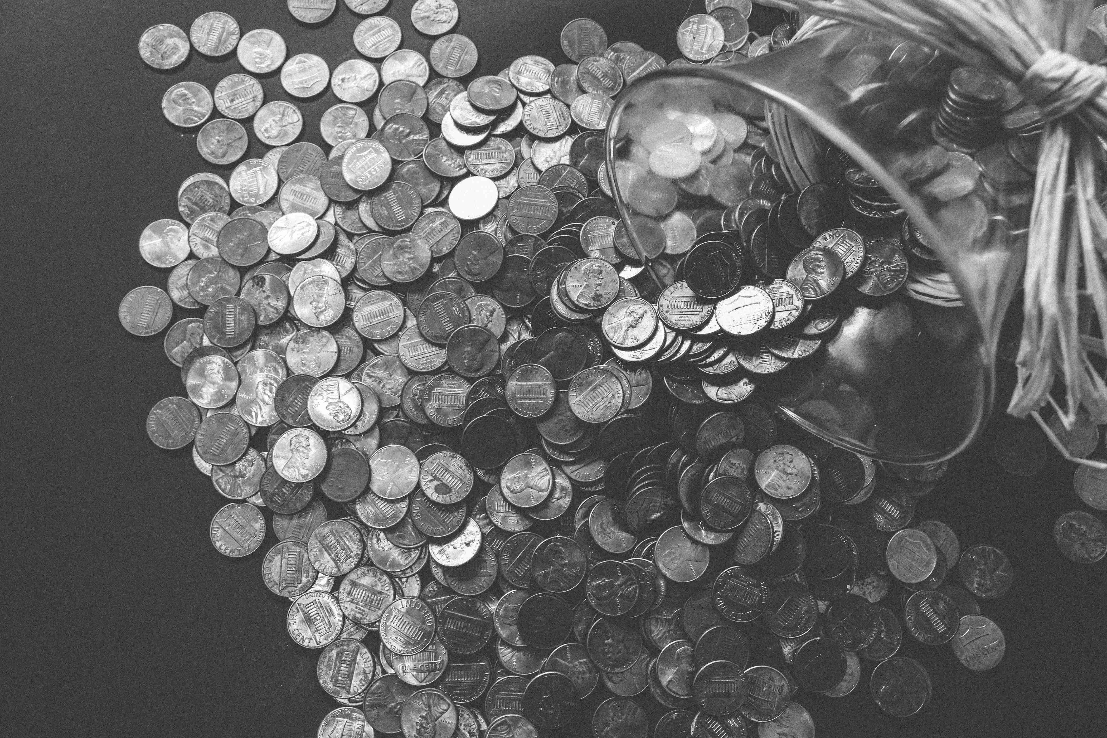 Glass jar spilling coins across a table